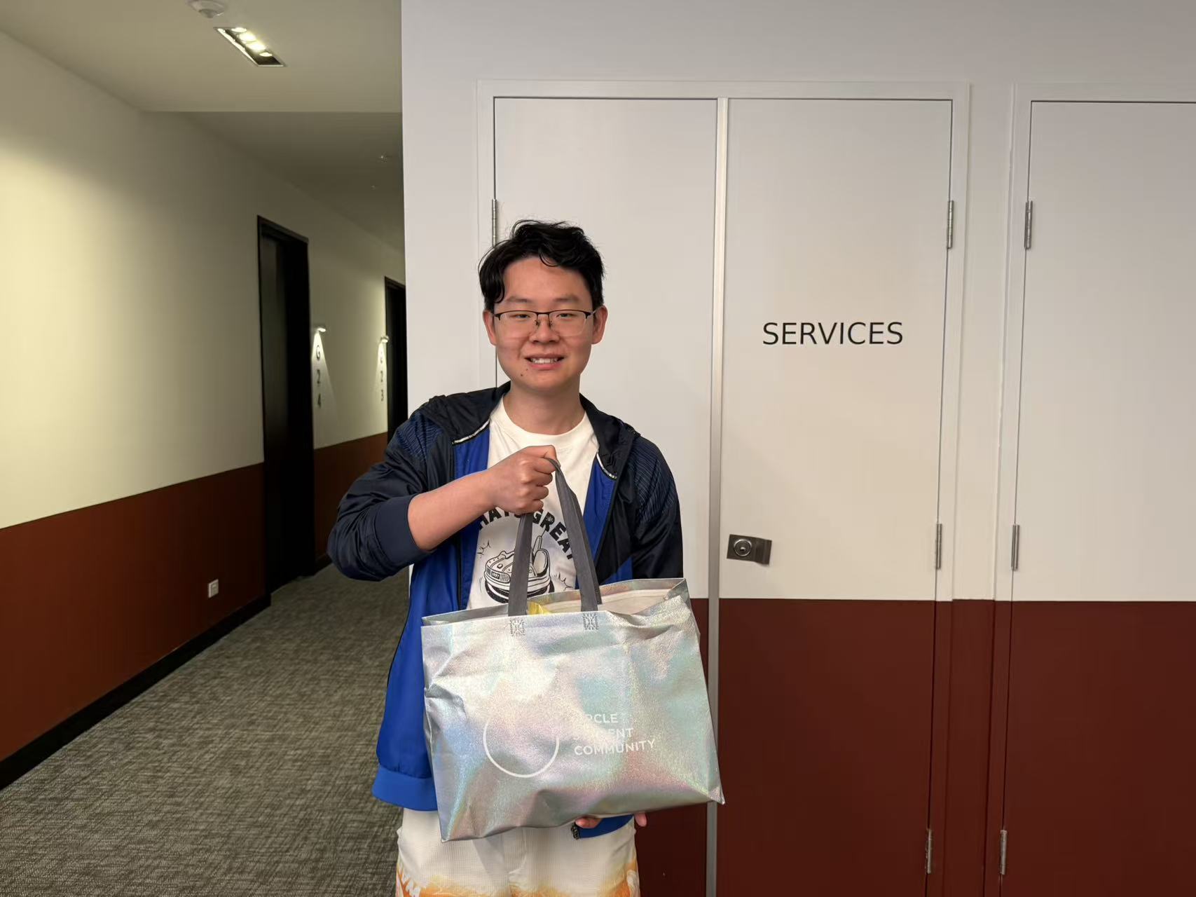 Circle student smiling with his Mid-Autumn gift bag at Circle Stockdale